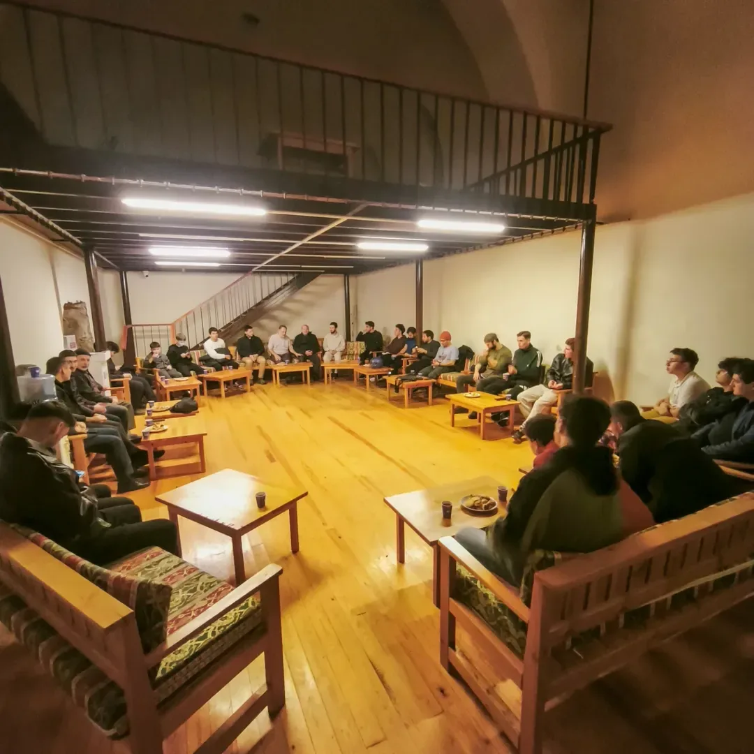 Karatay Medresesi'nin ahşap zeminli salonunda halka kurulmuş gençlik meclisi